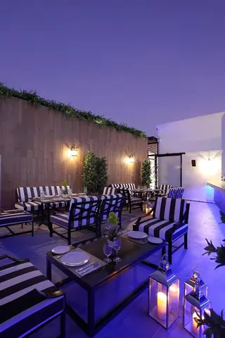 Villa De Khaosan rooftop dining terrace at night